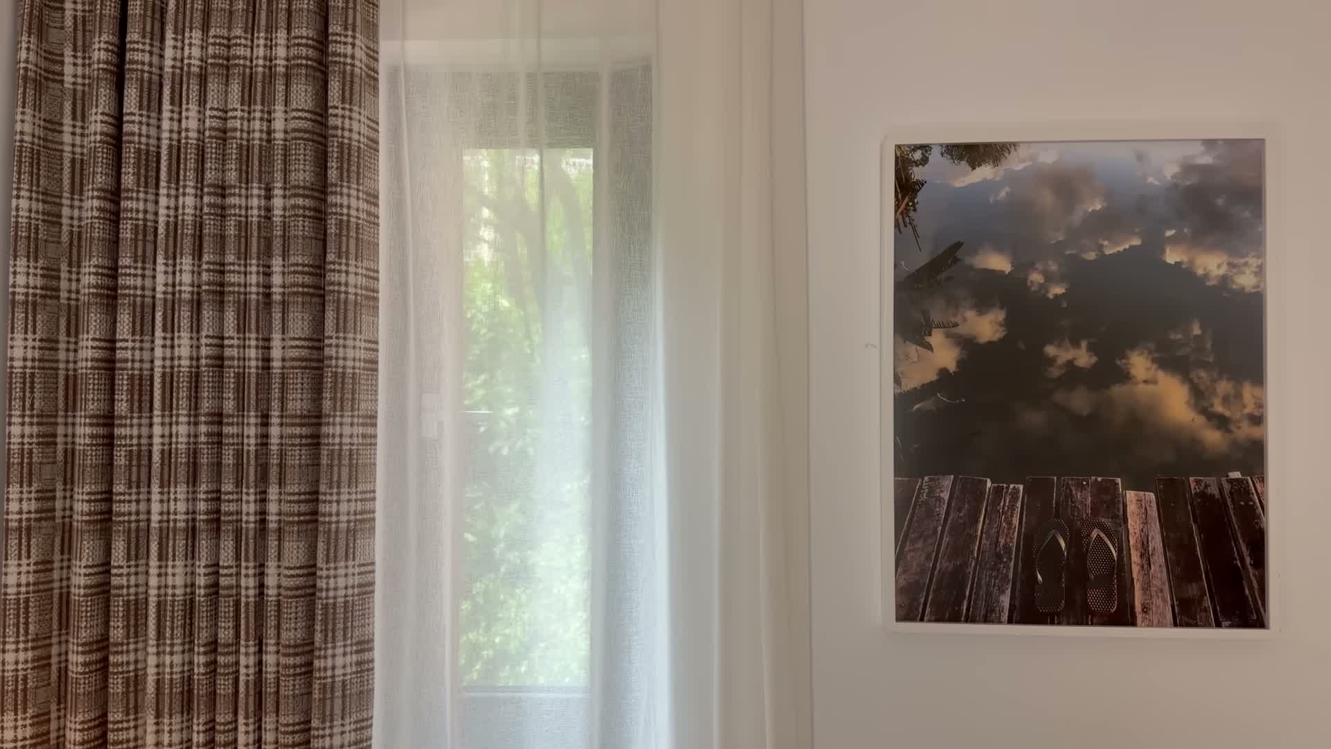 Plaid linen curtains framing the bedroom window, hung well above the frame